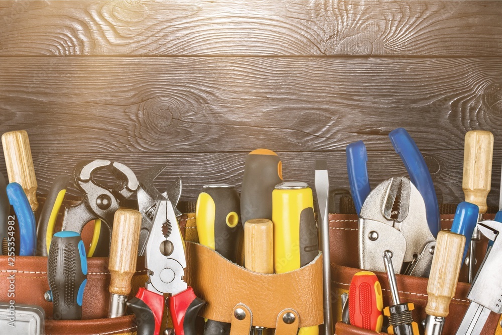 Wall mural Tool belt with tools on wooden background