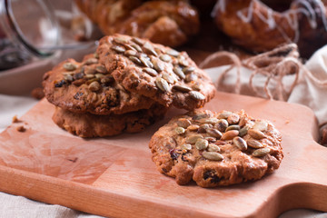 Oatmeal vegetarian cookies with pumpkin seeds. Wooden background