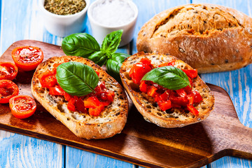 Bruschettas on cutting board on wooden background