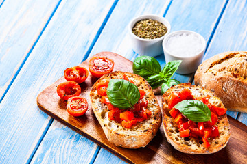Bruschettas on cutting board on wooden background