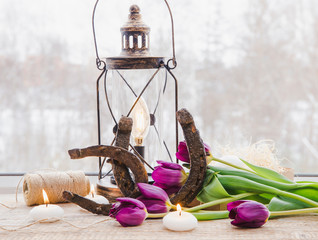 Two old rusty horseshoes, brown vintage lantern with modern dimmable decorative light bulb switched...