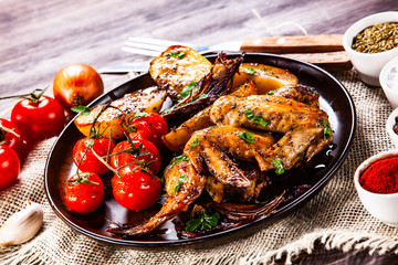 Roast chicken wings, baked potatoes and vegetables