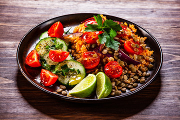 Groats with lentils and vegetables on wooden table