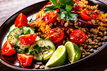 Groats with lentils and vegetables on wooden table