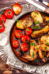 Roast chicken wings, baked potatoes and vegetables