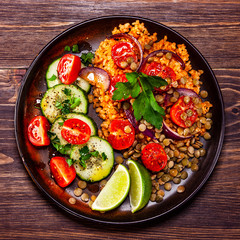 Groats with lentils and vegetables on wooden table