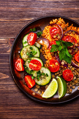 Groats with lentils and vegetables on wooden table