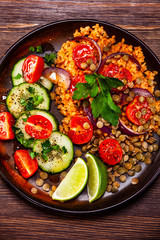 Groats with lentils and vegetables on wooden table