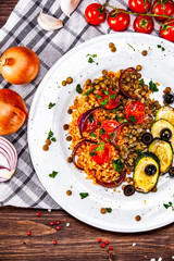 Groats with lentils and vegetables on wooden table