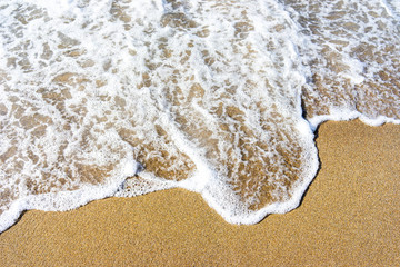 Soft wave of blue sea on sandy beach.