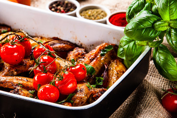 Grilled chicken wings with baked potatoes and vegetables