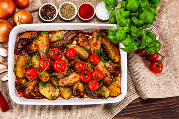 Grilled chicken wings with baked potatoes and vegetables