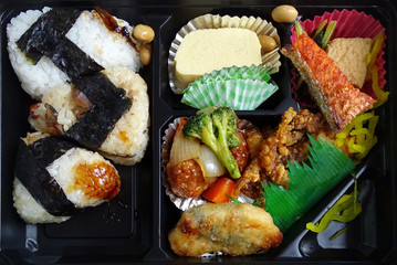 Black plastic lunch box with traditional japanese breakfast