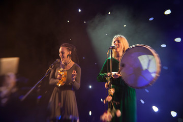 Young blond woman singer in concert light