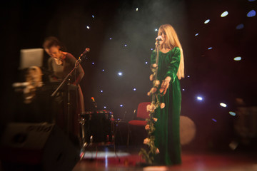 Young blond woman singer in concert light