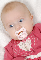 Baby girl lying on a white blanket