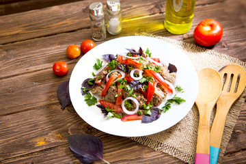 Fried liver with onion and tomatoes on wooden background