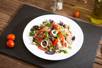 Fried liver with onion and tomatoes on wooden background
