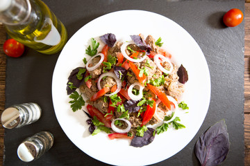 Fried liver with onion and tomatoes on black stone background