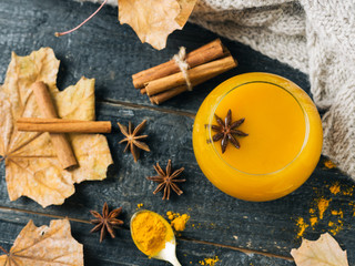 turmeric tea with cinnamon and ginger on wooden background