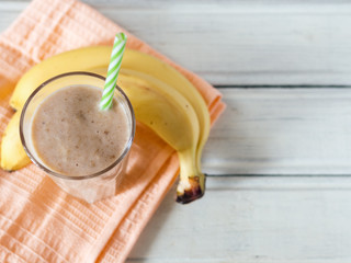 Banana smoothie on wooden white background, healthy food