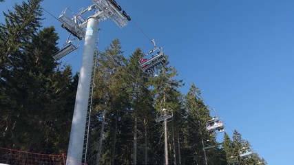 skiers on ski elevator winter sunny day in the mountains