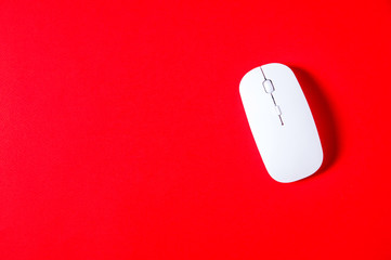 White computer mouse on a bright red background