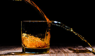 whiskey with ice cubes on wooden background