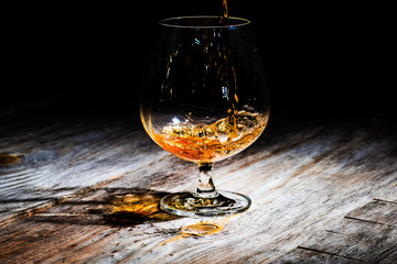 glass with cognac on a wooden background