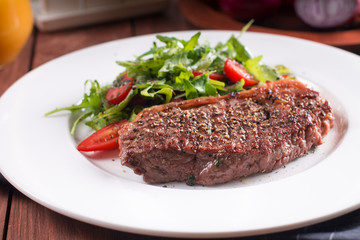 Beef steak with vegetables. Barbecue meat beef tenderloin. wooden background