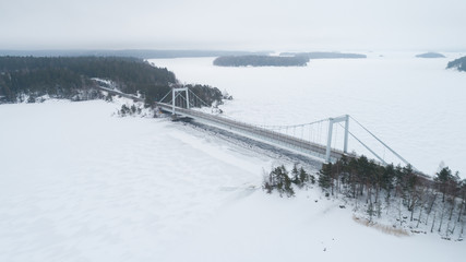 Aerial view of bridge and frozen lake in snow at winter
