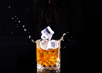 shot of whiskey with splash on black background, brandy in a glass