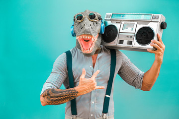 Crazy senior man dancing rock music wearing t-rex mask