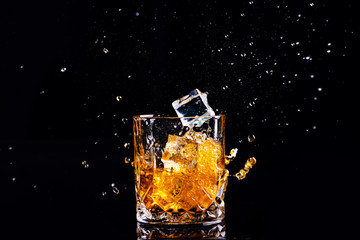 shot of whiskey with splash on black background, brandy in a glass