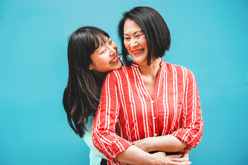 Asian mother and daughter having fun outdoor - Focus on faces