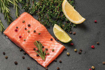 Raw salmon, trout fillet on a dark slate background. Wild atlantic fish. Healthy food.