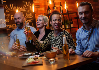 Group of friends having fun talk behind bar counter in a cafe