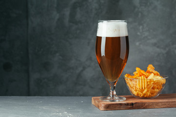 Glass of dark beer with bowl of beer snacks close up