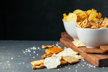 Beer snacks on stone table. Various crackers, potato chips. Top view
