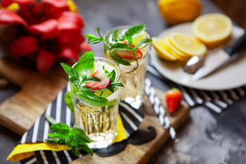 Refreshing summer beverage with lemon, mint and ice. Glasses with cold and healthy drink, place for text