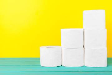 Toilet paper stacks  on bright yellow background
