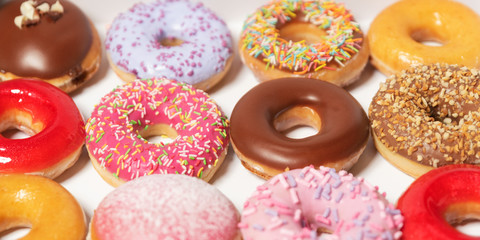 Assorted donuts with different fillings in cardboard box for pastry delivery isolated on white background.  Sweet fast food concept. Tasty dessert doughnuts cake from bakery of breakfast