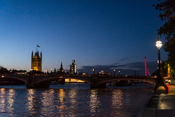 View of the Thames and Houses of Parliament and London Eye at night, London, UK