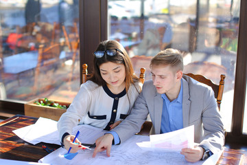Female student talking with architecture professor art cafe.