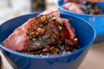 Red meat in blue bowl with spices and sauces