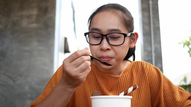 Closeup portrait with Asian young woman with hypersensitive teeth eating ice cream. Health and tooth Problem concept.
