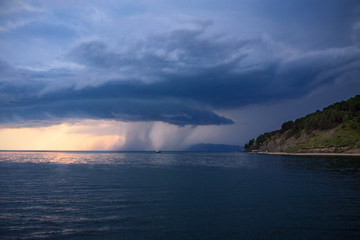Lake Baikal before the storm. Sunset, summer, storm, a shower in the distance.