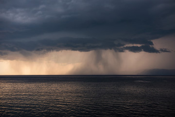 Lake Baikal before the storm. Sunset, summer, storm, a shower in the distance.