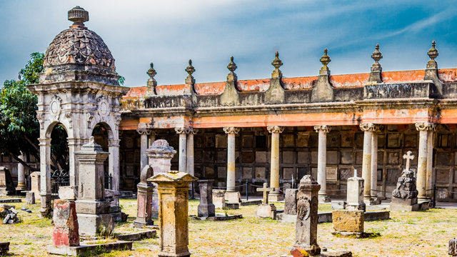 Historical museum and cemetery of Belen with ancient tombs and urns in background, orange paint worn by time, magical and mysterious day full of legends. Mexican culture in Guadalajara, Jalisco Mexico