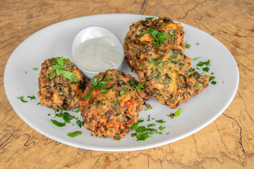 Vegetarian meatballs. With spinach, zucchini, parsley. Panned with breadcrumbs. Garnished with garlic sauce.